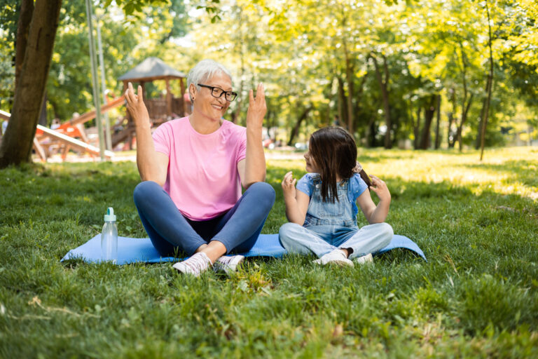 Enkelkind mit Oma im Grünen beim Yoga